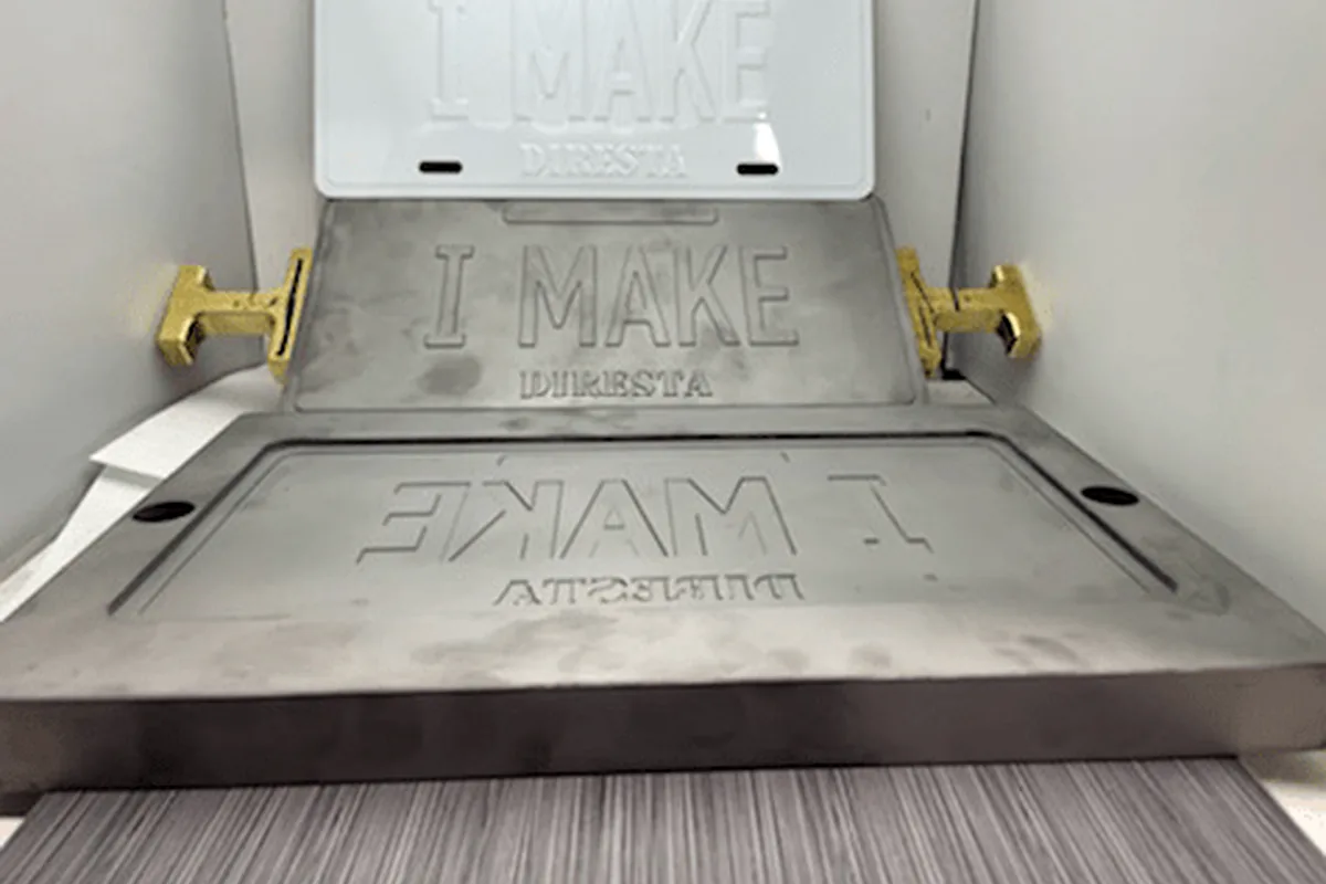 Embossing die tooling used for raised and recessed plate identification.
