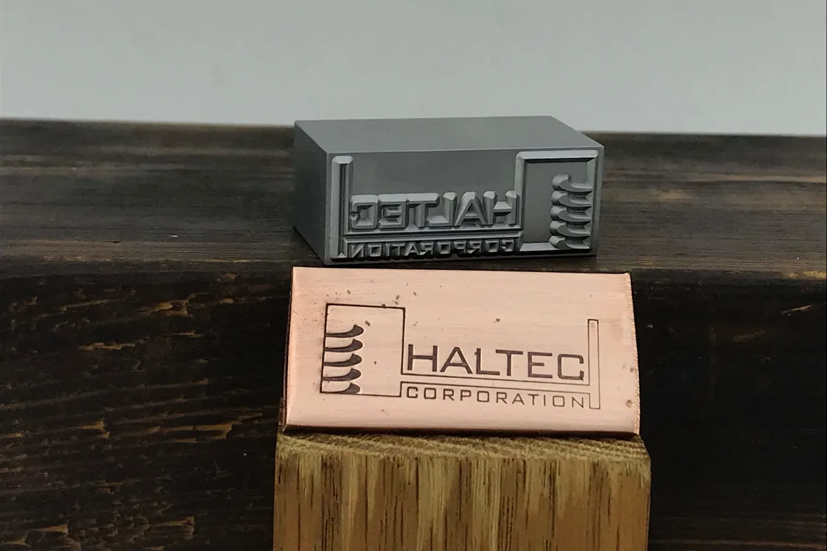 Custom marking die and copper sample for automotive-style traceability work.