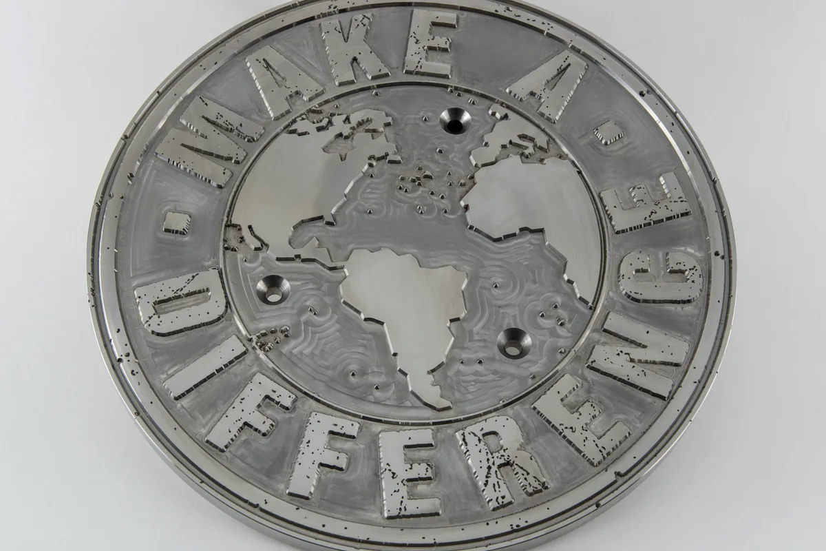Special engraved circular plate with detailed lettering and relief work.