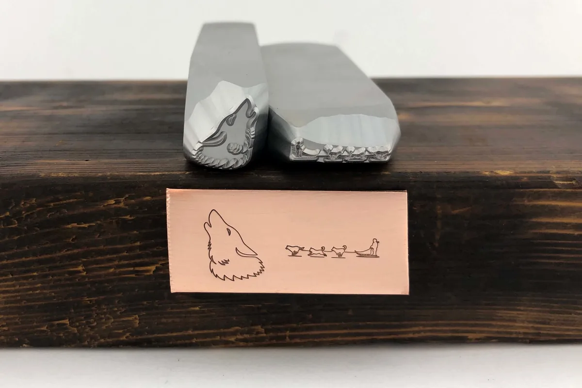 Custom wolf symbol hand stamp and copper stamped sample showing fine detail.